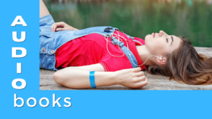 A girl lays outside listening to an audiobook on her phone
